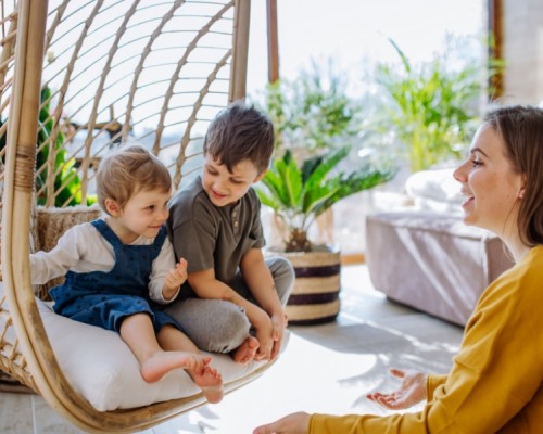 Mother talking to two children in a conservatory
