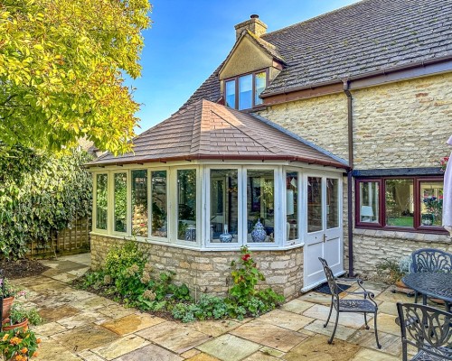 Conservatory fitted with CI Groups' insulation with a fireplace and dining area